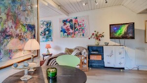A living room with a round table, a television, and abstract paintings on the wall. - Nice home in Härryda with WiFi (Härryda)