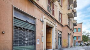 Fila de botigues tancades amb persianes metàl·liques, una porta de fusta i una petita tenda.