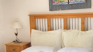 A bed with a patterned bedspread, a wooden headboard, and two pillows. - Posada d'lua (Villa Carlos Paz)