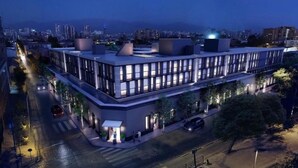 Un edifici modern amb teulada plana, grans finestres i entrada cantonera.