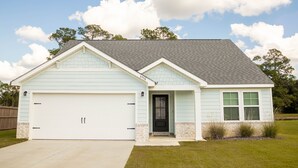 A single-story house with a garage, a front door, and a small porch.