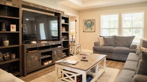 A living room with a large entertainment unit, a grey sofa, and a coffee table.