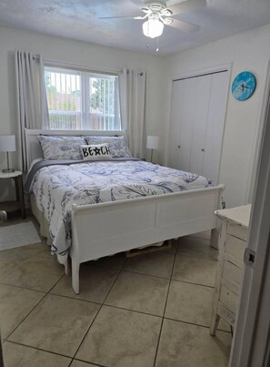 A bedroom with a bed, a nightstand, a dresser, a ceiling fan, and a window with curtains. - Relaxation! Private home with a pool, Perdido Key. Johnson Beach 10min away. (Pensacola)