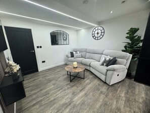 Relax in this stylish living room with a comfortable sofa, coffee table, and potted plant.