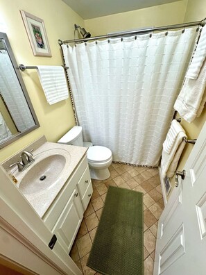 Een badkamer met wastafel, toilet en douchegordijn.
