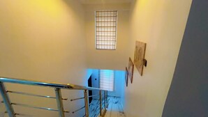 Eine Treppe mit Metallgeländer und einem Fenster mit Jalousien.