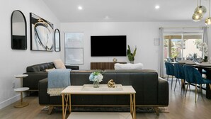 Un salon moderne avec un canapé, une table basse et un coin repas.