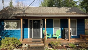 A small house with a porch, a front door, and two green chairs. - Music Place Guest House (Maple Falls)