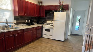 Una cocina con armarios de madera, un refrigerador blanco y una estufa.