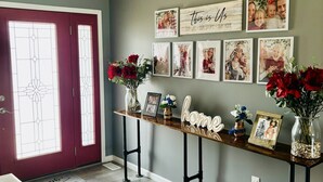 A hallway with a wooden bench, framed photos, and a 'This is us' sign.