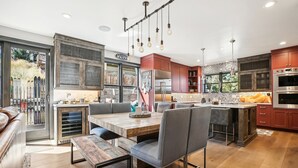 A modern kitchen with wooden cabinetry, a large island, and pendant lighting.