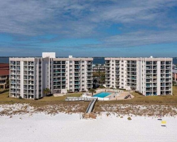 Un hotel moderno de gran altura con varias plantas, una piscina y vistas a la playa.