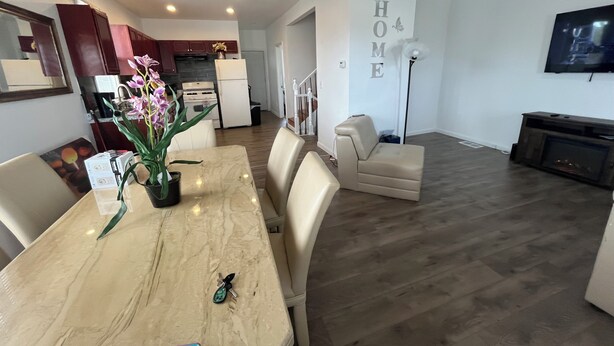 Una sala de estar moderna con comedor, sofá, televisor y chimenea.