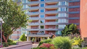 A multi-story hotel with a modern design, featuring balconies on each floor and a landscaped garden in front. - Coastal Charm – Breathtaking Views with Work Desk by Victoria Prime! (Victoria)