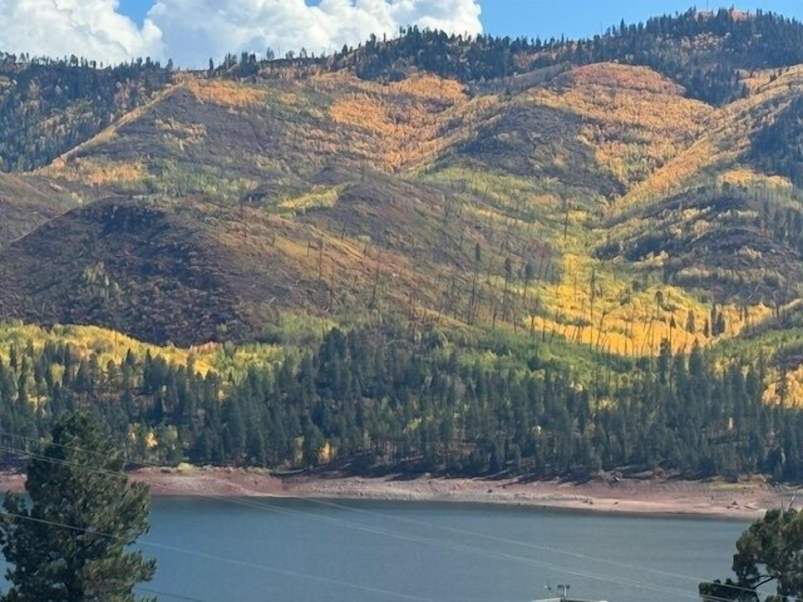Paisagem montanhosa com um lago ao primeiro plano.