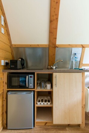 A compact kitchenette with a microwave, toaster, and sink. - Cosy Rural Cabin With Hillside Viewpoint (Moffat)