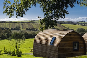 Une cabane en bois avec un toit en pente, une petite fenêtre et une plaque portant son nom.