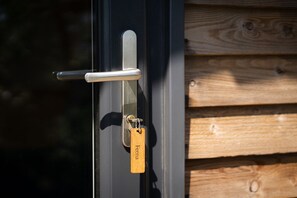 Een deur met een metalen handvat en een houten sleutelhanger met de naam 'Feena'.