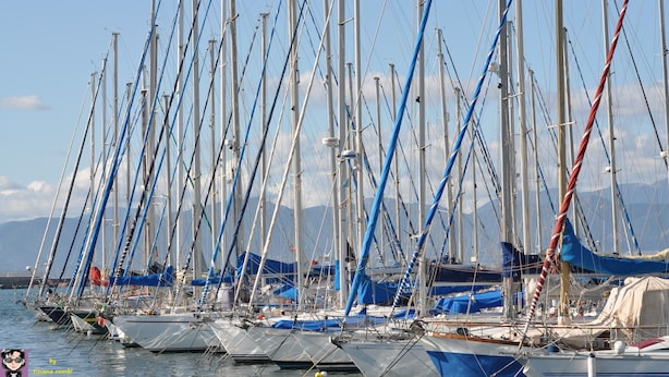Ein Yachthafen mit mehreren Segelbooten, die an den Stegen liegen, inklusive Masten und Takelage.
