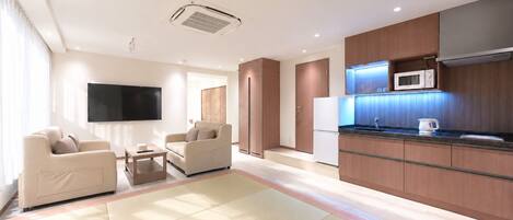 A modern living room with a flat-screen TV, two sofas, and a coffee table.