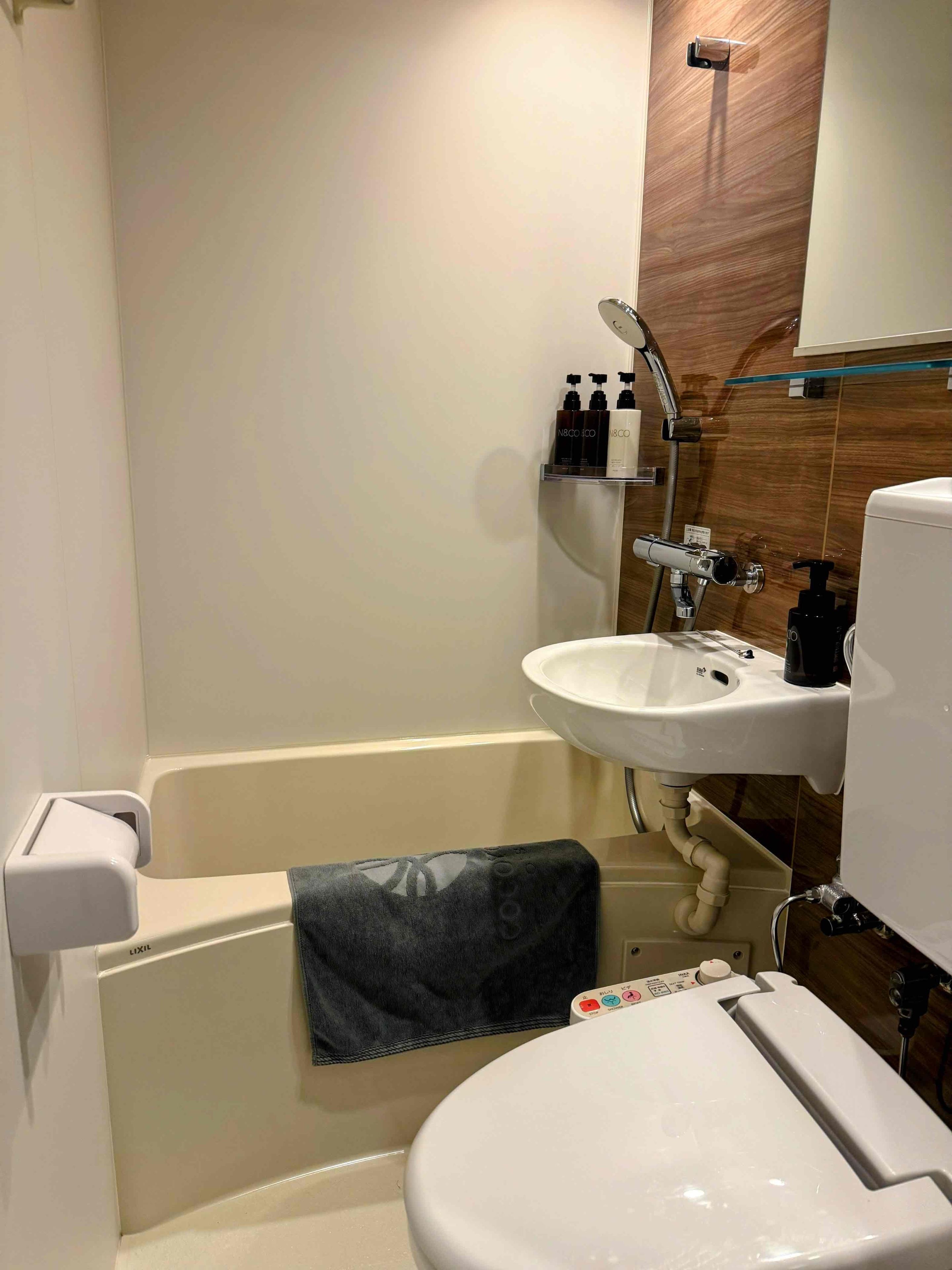 A bathroom with a bathtub, toilet, sink, and a mirror.