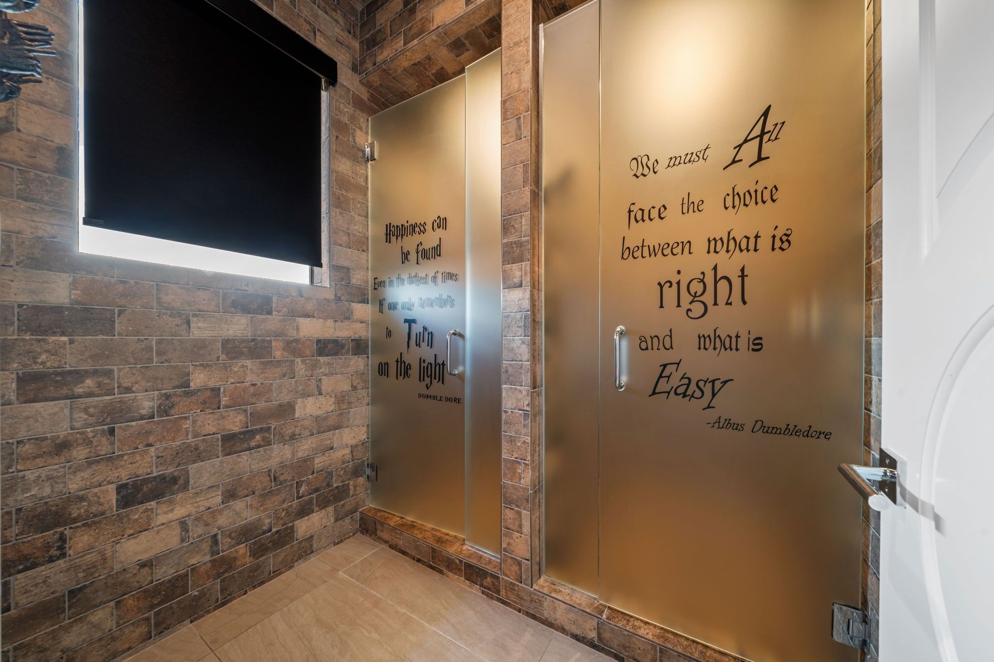 A hallway with a brick wall and two doors with motivational quotes.