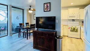 A modern kitchen with white cabinets, a microwave, and a stove.