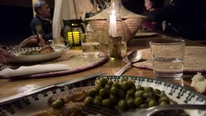 Una tavola imbandita con piatti di cibo, bicchieri e una candela.