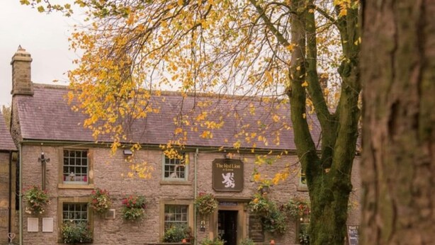A stone building with a sign reading "The Red Lion."
