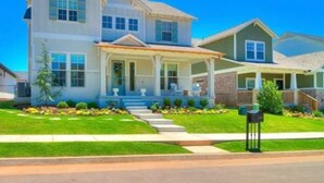 A two-story house with a front porch, a covered entryway, and a well-maintained lawn.