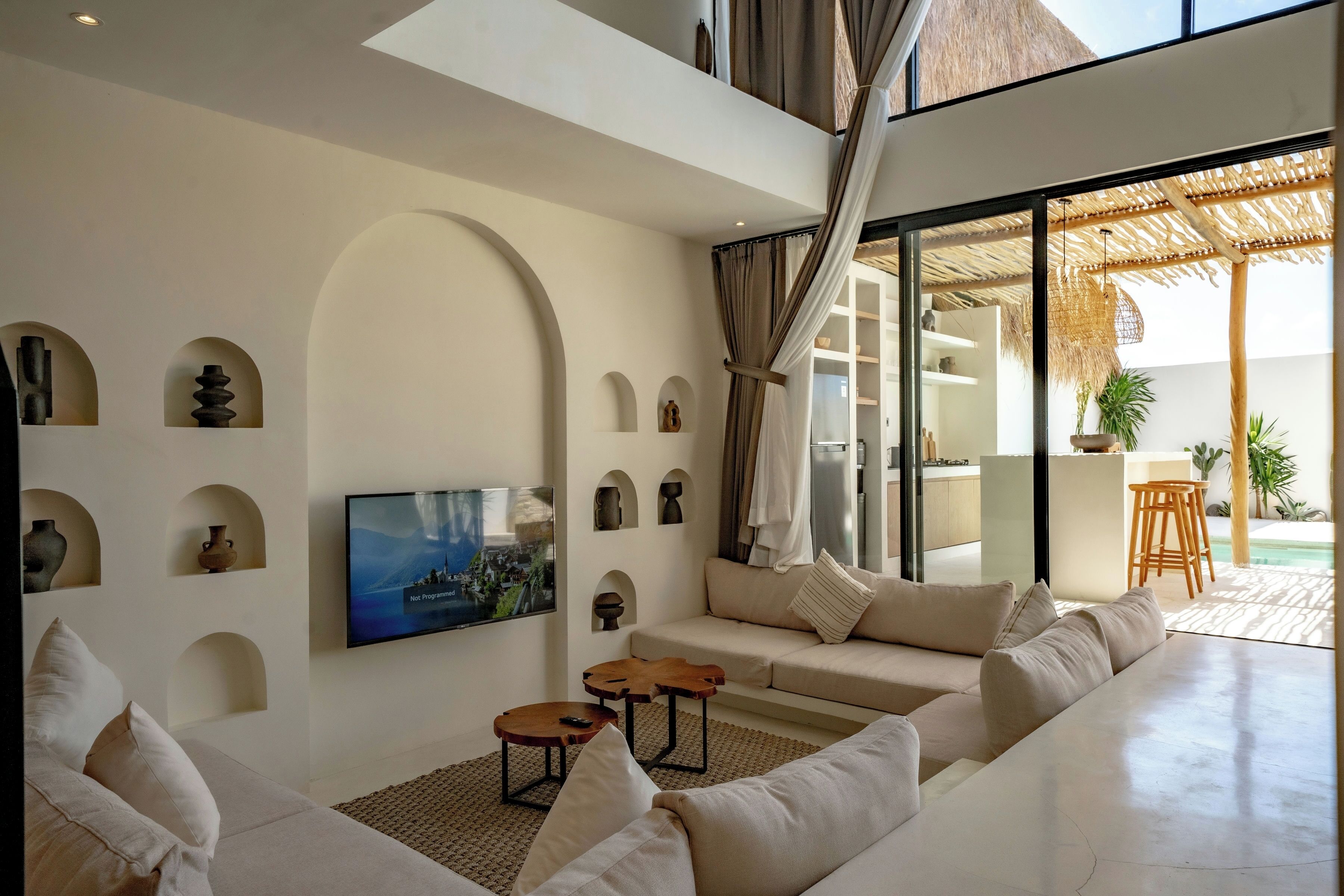 A modern living room with a large flat-screen TV, a sofa set, and a coffee table.