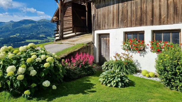 A wooden chalet with a balcony overlooking a mountainous landscape.