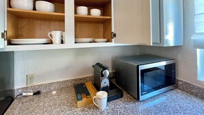 A kitchen with a microwave, coffee maker, and a cabinet with dishes. - Sunnyvale Cabin (Sunnyvale)