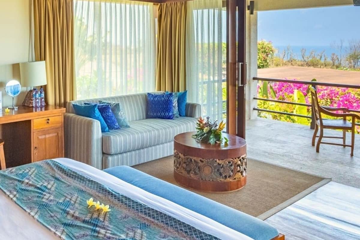 Ein Schlafzimmer mit Bett, einer Couch, einem Couchtisch und einem Balkon mit Blick.
