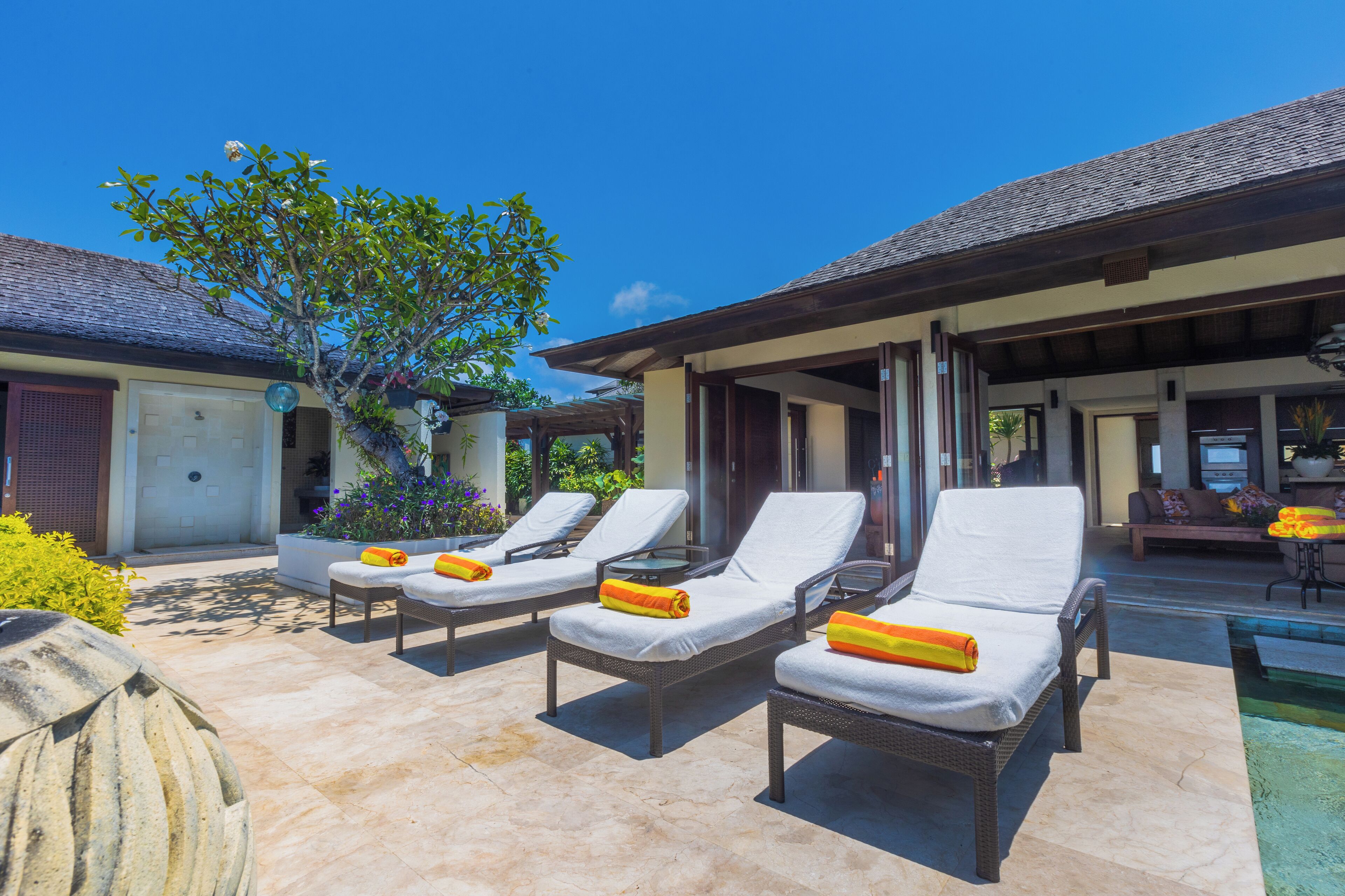 Un espace aménagé au bord de la piscine, avec des chaises longues et une petite piscine.