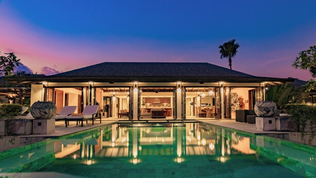 A modern house with a swimming pool, outdoor seating, and a well-lit interior. - Villa Cantik Pandawa By Fays Hospitality (Kutuh)