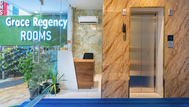 A reception area with a glass wall displaying 'Grace Regency Rooms'. - Grace Regency (Kanayannur)