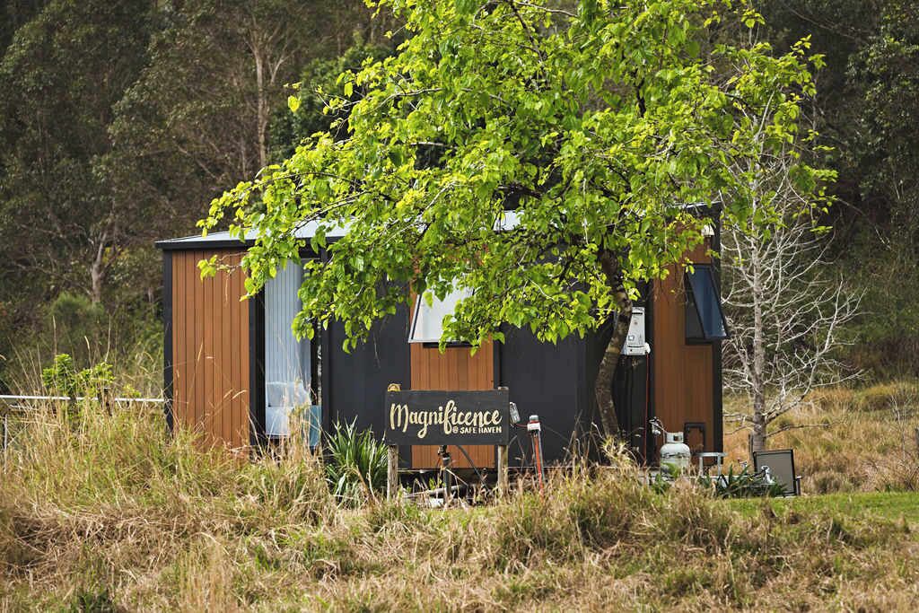 Eine kleine, rustikale Holzhütte mit einem Schild, auf dem 'Magnificence' und 'Safe Haven' steht.