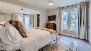 A bedroom with a bed, a TV, and a window with curtains. - Sweet Sage Cottage in Old Town Close to the Square (Georgetown)