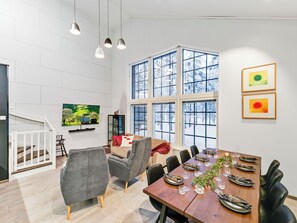 A modern dining area with a high ceiling, large windows, and contemporary furniture. - Levin hetki b by Interhome (Kittilä)