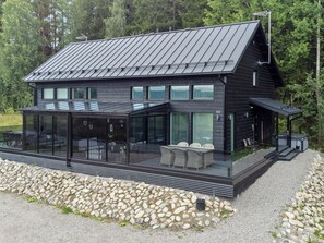 A modern two-story house with a flat roof, large windows, and a covered outdoor seating area. - Himos alppinotko 6 b by Interhome (Kuhmoinen)