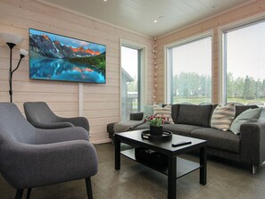 A modern living room with a large flat-screen TV, grey sofas, a coffee table, and a lamp. - Himos alppinotko 6 b by Interhome (Kuhmoinen)