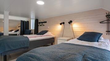 Un dormitorio moderno con dos camas, una pared de madera y un espejo.