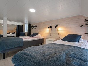 Un dormitorio moderno con dos camas, una pared de madera y un espejo.