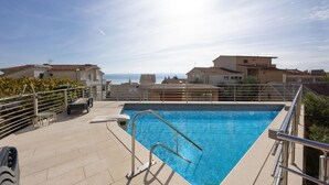 A rooftop swimming pool with a clear view of the sea and surrounding buildings. - Nice apartment in Dugi Rat with WiFi (Dugi Rat)