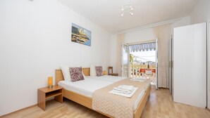 A bedroom with a bed, bedside table, and a painting on the wall. - Nice apartment in Dugi Rat with WiFi (Dugi Rat)