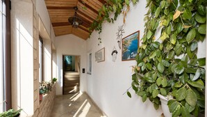 A hallway with a wooden ceiling, a welcome sign, a framed painting, and potted plants. - Nice apartment in Dugi Rat with WiFi (Dugi Rat)