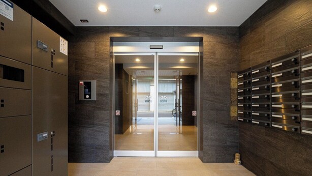 An elevator entrance with a digital control panel, a glass door, and a wall-mounted mail slot. - MAT OSAKA NAGARA (Osaka)
