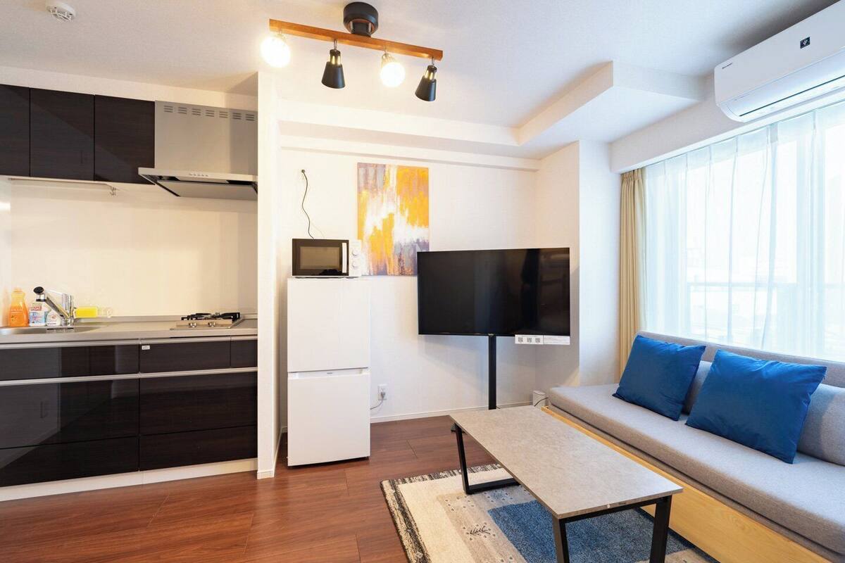 A modern apartment with a kitchen, dining area, and living room.