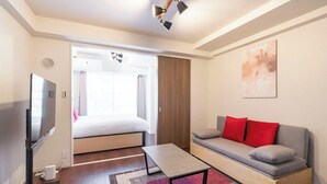 A modern hotel room with a bed, a sofa, a TV, and a ceiling fan. - MAT OSAKA NAGARA (Osaka)